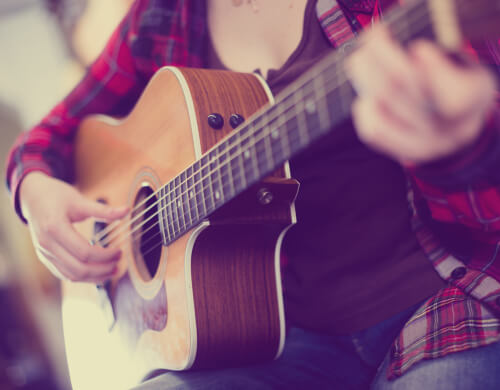 Chica tocando la guitarra.