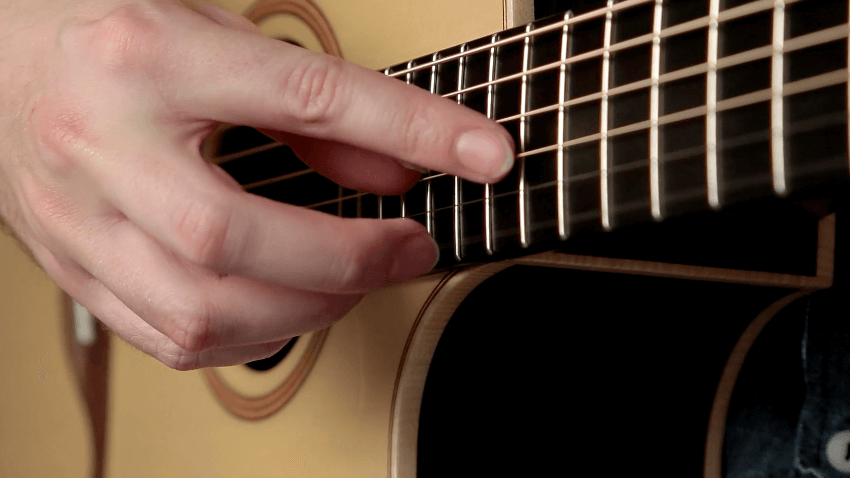 Guitarrista ejecutando armónicos en la guitarra