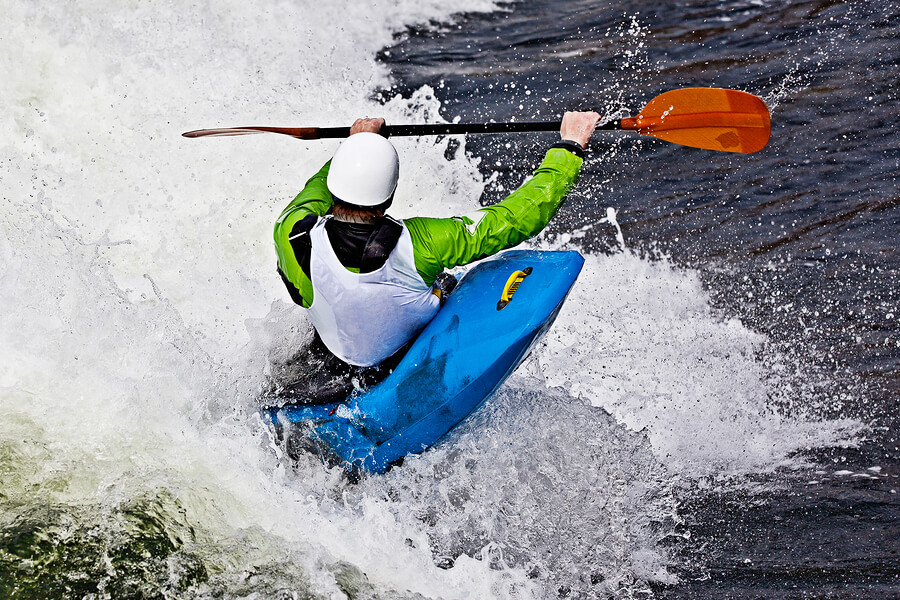 Hombre toma una ola haciendo kayak surf.